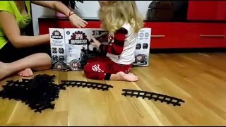 Девочка с родителями играет в детскую железную дорогу. The girl's parents plays to the railway