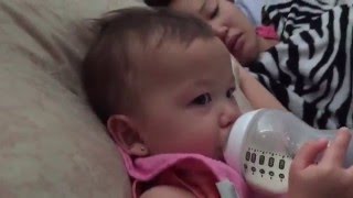 Cute laughing baby drinking milk bottle