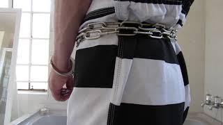 Prisoner in Peerless Security Chain, Handcuffed in Smith & Wesson Model 100-1 handcuffs.