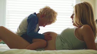 SPECIAL MOMENTS - Pregnant blonde mother and son laying on a bed, family love stock video footage