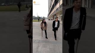 Two onelegged Chineses walk on the one crutch