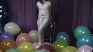 Sexy brunette popping balloons