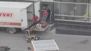 Грузчики рассыпанный по асфальту товар в магаз отправили