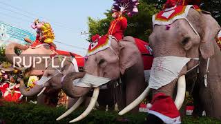 Elephants dressed in Xmas costumes hand out presents to school children in Thailand