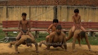 Indian wrestlers do push-ups with kids on their backs