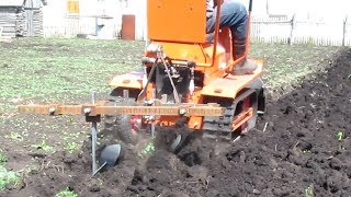 Минитрактор пашет двухкорпусным плугом