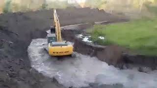 Pé de chumbo trabalhando na escavadeira da NEW HOLLAND 245 fazendo açude