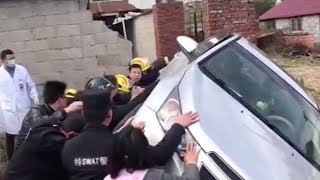 Passersby and rescue workers lift car to free woman trapped underneath