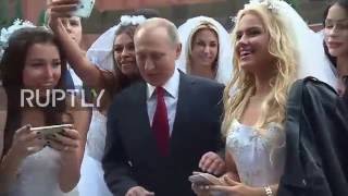 Russia: Putin mobbed by young models dressed as brides