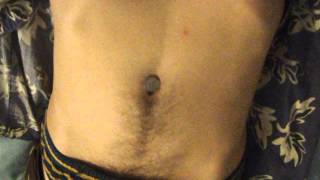 Belly button play with objects in navel of shirtless guy