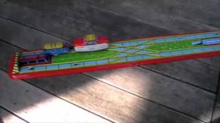Tin toy train loads and unloads