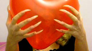 Margarita Tade popping balloons with her long nails