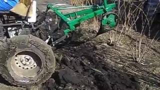 Самодельный трактор пашет землю.