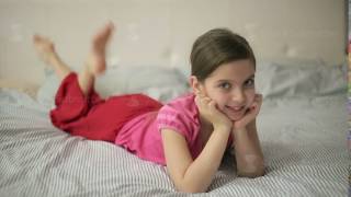 Girl lying on the bed moves feet