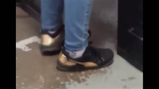 Bossy girl's feet wrapped in Gold Puma Sneakers