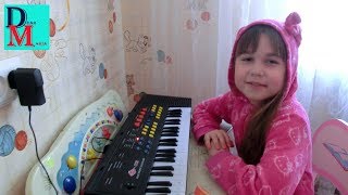 Маша учится играть мелодии на детском синтезаторе.