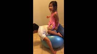 Little girl getting a horsey back ride on little boy
