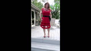 Crossdresser wearing a red dress with black accents on deck