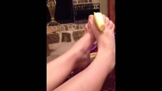 Girl peeling banana with feet