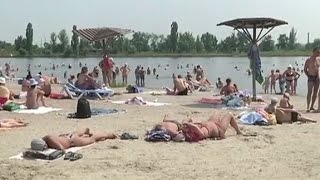 Жители прифронтовых городов загорают и купаются в считанных километрах от линии соприкосновения