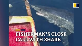 Fisherman has a close call with shark circling his boat in Indonesia