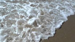 Water taking the sand from underneath your feet in Huntington Beach