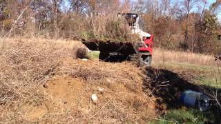 Takeuchi TL250 digging and piling up dirt