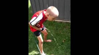 Boy is peeing on dog