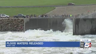 People gather as flood waters are released from Perry Lake