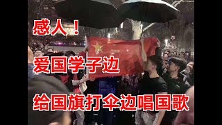 感人！爱国学子边给国旗打伞边唱国歌
