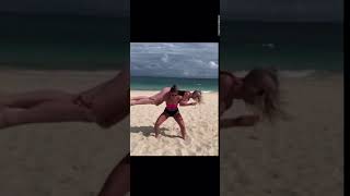 Girl Funnily Does Squats on Beach While Carrying Friend on Her Shoulders - 1101413