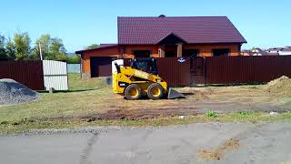 Минипогрузчик планирует щебень на дороге в Белгороде