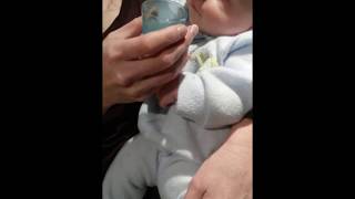 drinking breast milk from a shot glass at 2 months old