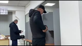 Перевыборы февраль, 2022, Бишкек: Избиратель говорит по телефону в кабинке для голосования