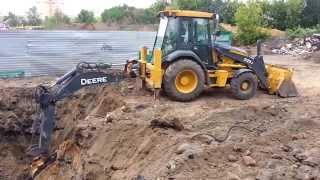 Экскаватор погрузчик John Deere в работе